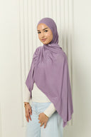 Woman wearing a purple hijab against a white background